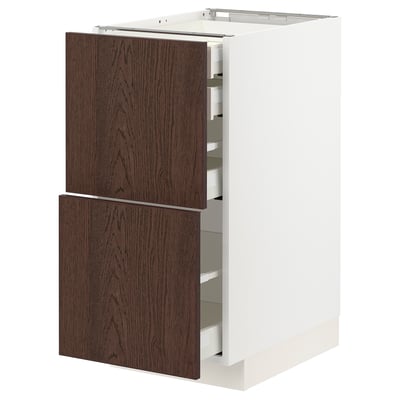 A white METOD kitchen cabinet with dark brown sinarp drawer fronts. It has multiple drawers in a rectangular shape.