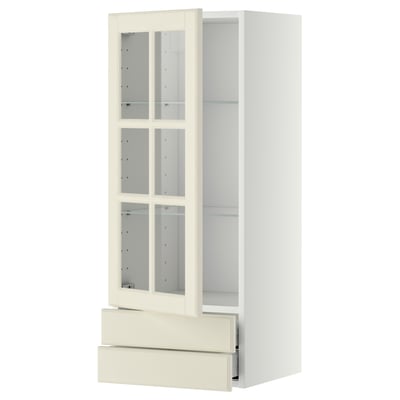 An off-white taller kitchen cabinet with glass doors and drawer.