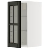 A black glass door cabinet from the METOD kitchen system. It has a sleek, modern design with beveled edges and a sturdy frame.