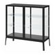 Black MILSBO glass-door cabinet with adjustable shelves. Modern and sleek design for displaying items securely.