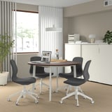 MITTZON round conference table with 4 black chairs. Walnut top, metal legs, compact for small meetings.
