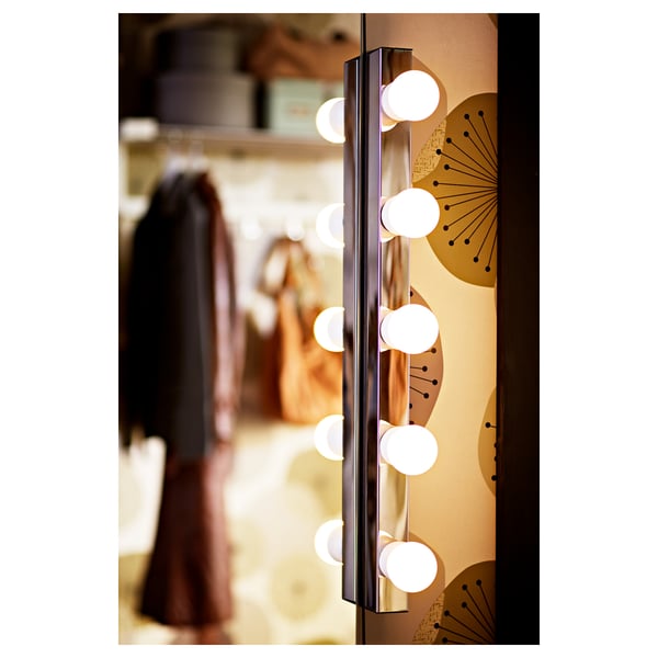 Vertical light fixture with globe bulbs in a room, likely a bathroom.