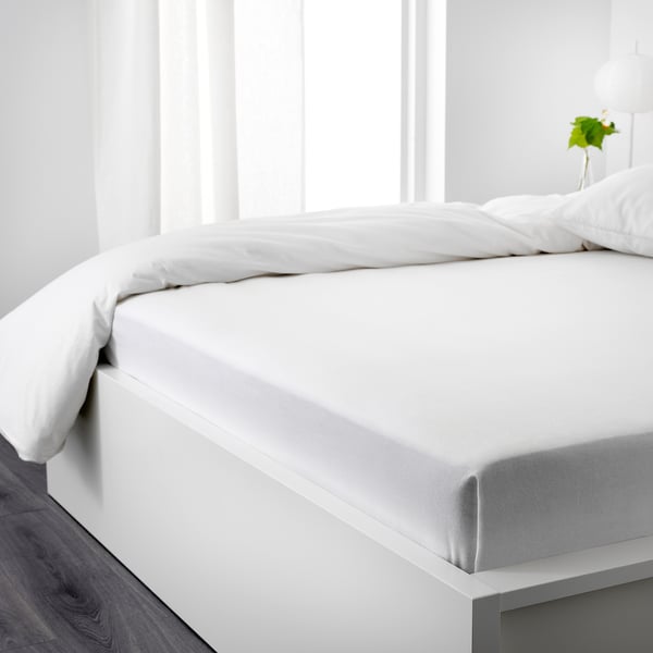 Crisp white bed with flannel sheets, soft and warm, perfect for cozy nights.