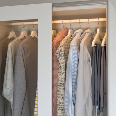 Well-organized wardrobe with led lights, illuminating clothes on hangers.