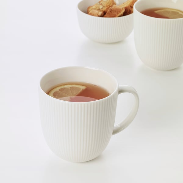 Three white mugs with lemon tea; one mug close-up shows lemon slice, suggesting refreshing flavor. Simplistic and elegant design.
