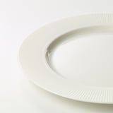 White porcelain plate with textured edge detail, smooth finish, pristine quality.