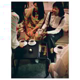 Three women enjoying tea on striped sofa with OLSERÖD table.