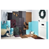 A colorful entryway mat display, featuring various sizes and colors of door mats, hanging baskets, and decorative items.