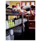 Shelves with stacked cups, cutlery, and jars in a kitchen setting.
