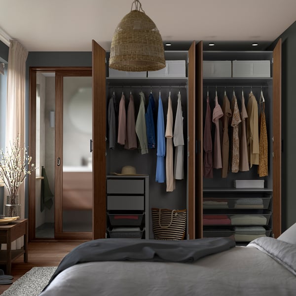 Modern bedroom with PAX wardrobe, hanging clothes, shelves, drawers, and pendant light.