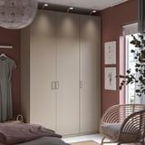 Beige PAX wardrobe, rattan chair, gray walls & art