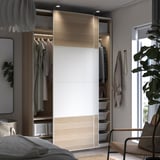 Modern bedroom with PAX wardrobe & wicker chair.