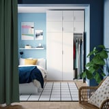 Modern blue bedroom with PLATSA wardrobe and bed, plant.