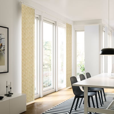 Modern dining area with PRÄRIEOXALIS curtains, black chairs, and striped rug.