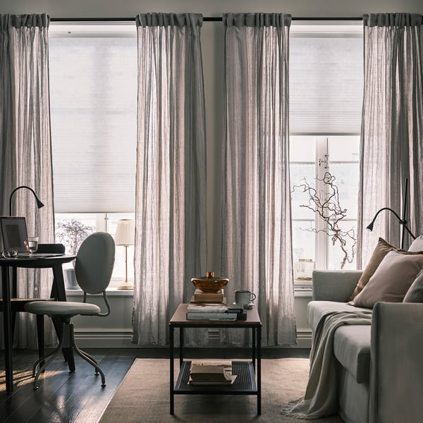 Modern living room with automated, cordless blinds and remote control for comfort and style.
