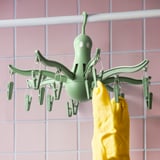 A PRESSA hanging dryer with 16 pegs, holding yellow socks. Its designed for drying small items like socks and underwear.