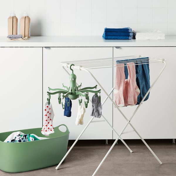 Octopus-shaped PRESSA hanger, white, holds clothes and socks. Sits on rack, fits near green basket.