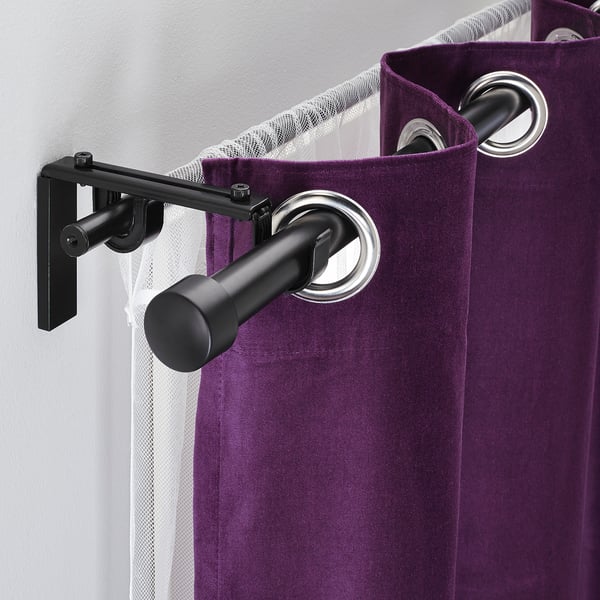 Black curtain rod holder with purple curtains. Allows hanging two curtain layers.