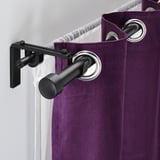Black curtain rod holder with purple curtains. Allows hanging two curtain layers.