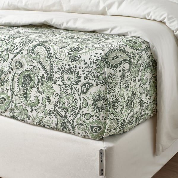 Neat bed with green paisley sheet, smooth texture.