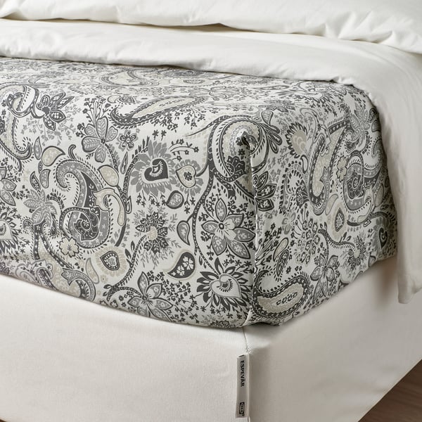 Bed flat sheet with paisley print, fine sheen, folded, showing thread tag.