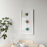 White ikea RÖDALM frame with abstract art above dining table.