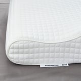 White pillow with textured cover, ROSENSKÄRM label visible, lying on flat surface.