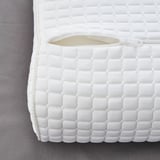 A close-up of a premium pillow with a textured, quilted white cover. It a zipper opening, indicating removable padding for easy washing.