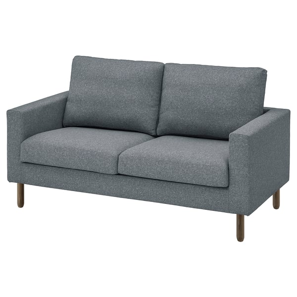 A grey SALTSJÖBADEN sofa. It has a sleek, modern design with rectangular cushions and wooden legs, providing a cosy yet stylish seating option.