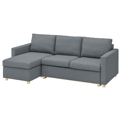 A grey IKEA SALTSJÖBADEN sectional sofa with wooden legs. It has a l-shaped design, comfortable cushions, and is made from recycled polyester.