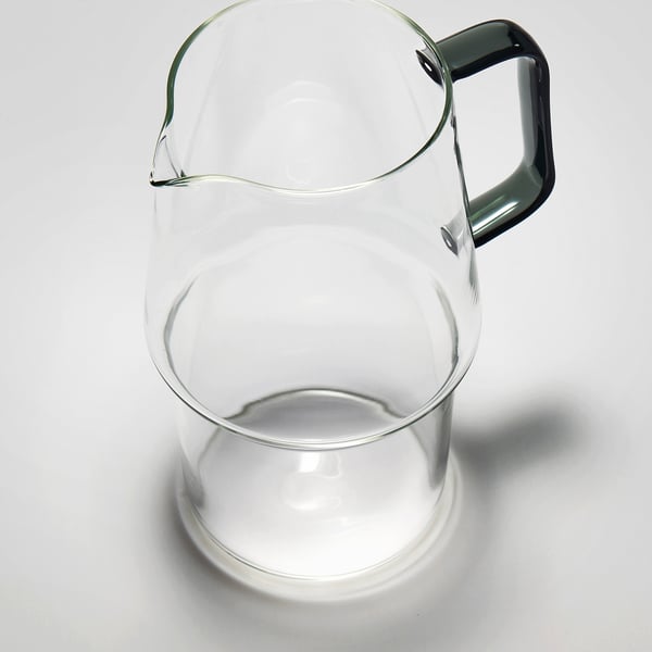 Clear glass pitcher with dark handle, durable, clear, sturdy.