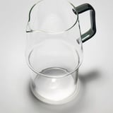 Clear glass pitcher with dark handle, durable, clear, sturdy.