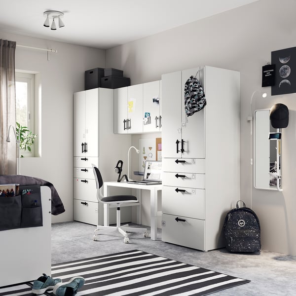 Modern teens room with white SMÅSTAD storage, desk, striped rug, and black accessories.