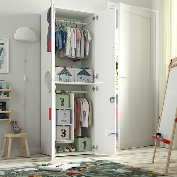 Childs wardrobe with clothes and storage bins, standing on wooden floor.