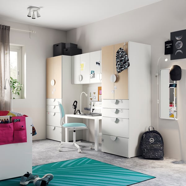 Modern kids room with white SMÅSTAD furniture: cabinets, desk, and wardrobe. Bright colors, organized space, and playful decor.