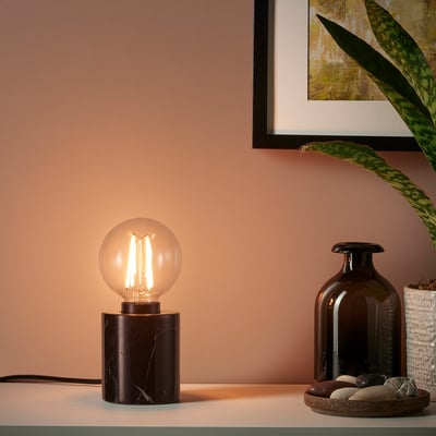 Modern desk with marble lamp, vase, bottle.