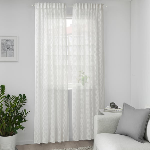 SOTSTÄVMAL white curtains, sheer, wave pattern, 100% recycled polyester, floor-length, central window, slim plant, gray pillow.