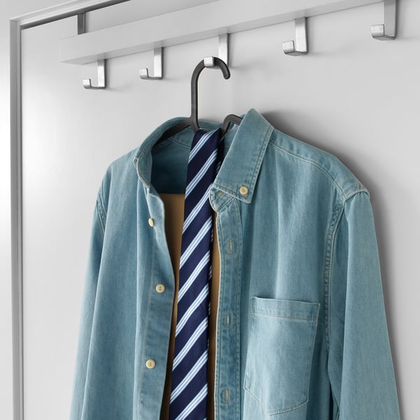 Clothes hanger holding blue shirt with tie, on white background.