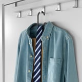 Clothes hanger holding blue shirt with tie, on white background.