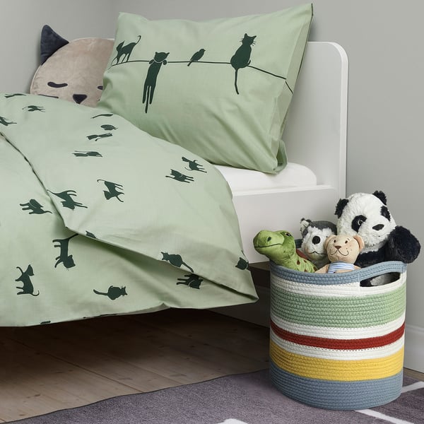 Green multi-striped cotton toy basket with panda and cat-themed bedding.