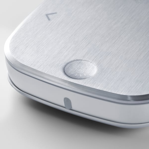 Stainless steel remote control with brushed finish, featuring a central button. Hardwearing and designer, suitable for modern decor.