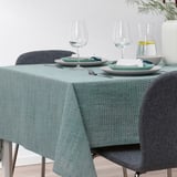 Table set with green-blue cotton tablecloth, plates, glasses, cutlery, vase with greenery. Suitable for 4-6 people.