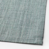 Close-up of woven green-blue cotton tablecloth, showcasing intricate texture and quality craftsmanship.