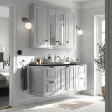 Modern bathroom with light grey TÄNNFORSEN cabinet set, marble counter, wall lamps, and plant.
