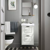 Modern bathroom with TÄNNFORSEN vanity, black toilet, grey towels, checkered floor, and wall mirror.