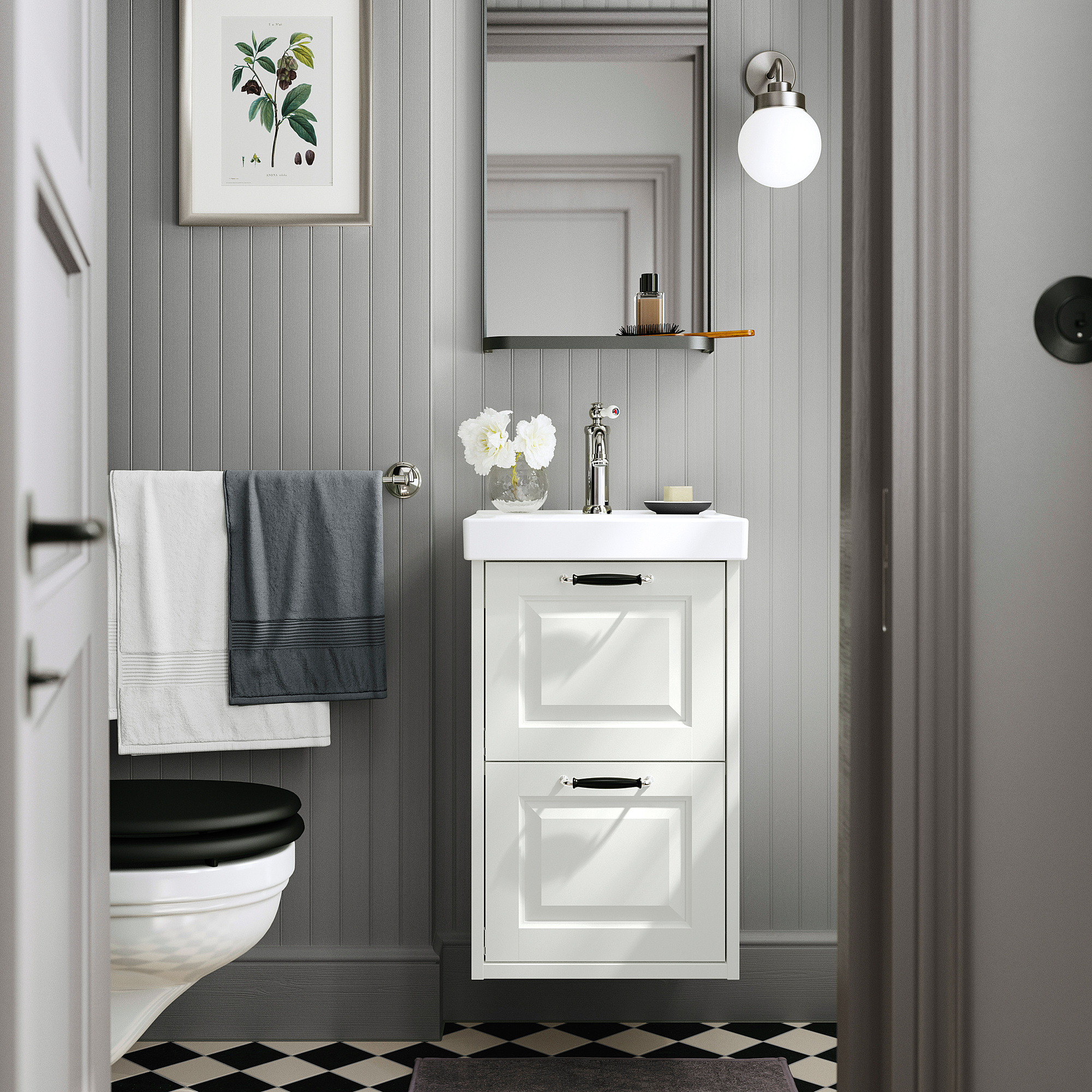 Modern bathroom with TÄNNFORSEN vanity, black toilet, grey towels, checkered floor, and wall mirror.