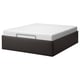 A TJÅLLE bed frame in black with a white mattress. It boasts a modern design with clean lines and offers hidden storage underneath.