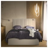 Modern bedroom with TJÅLLE bed, grey bedding, white headboard, wall sconces, wooden drawer, and curtained window.