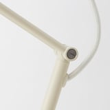 Updateable lamp with adjustable arm and shade, sleek cream finish, robust materials.