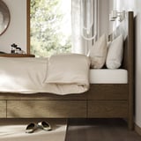 Bed with drawers, slatted base, and nightstand area.
